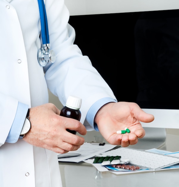 Closeup on man's hands with pills and bottle