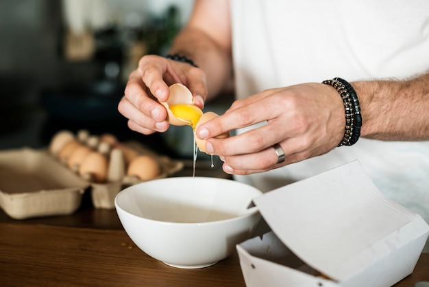 Closeup of man separating egg yolk