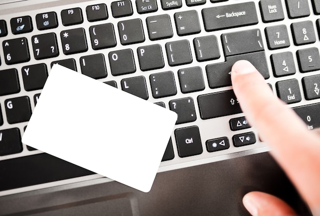 Photo closeup of a man shopping online using laptop with credit card. credit card is blank. credit card template