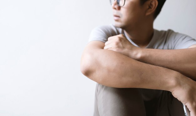 Closeup man sitting alone feeling sad