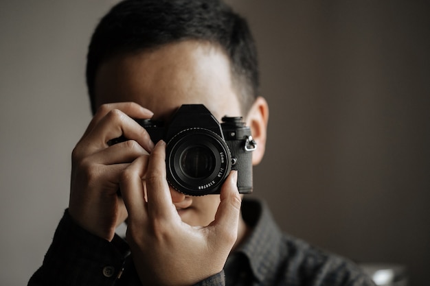 Closeup on man taking a picture on a pentax film camera
