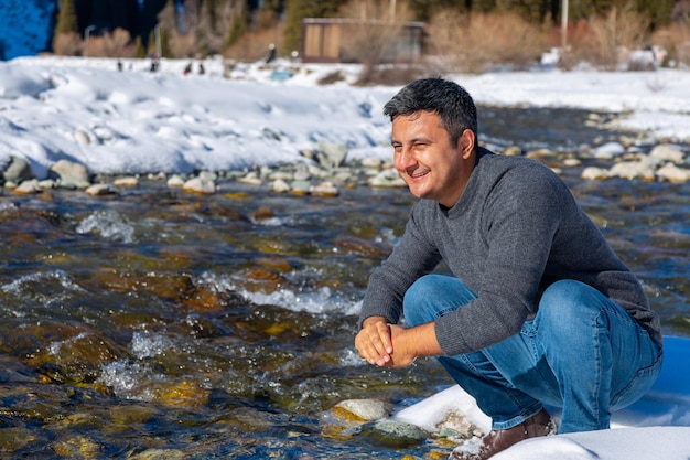 Closeup of man washing face with water from the river