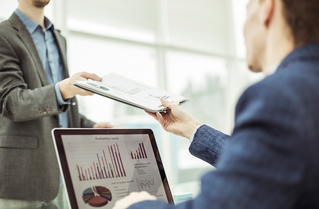 Closeup of Manager of Finance takes financial statement from the employee on a workplace at office