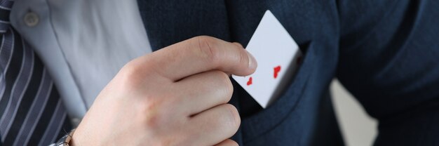 Closeup of mans hand pulling ace card out of suit pocket