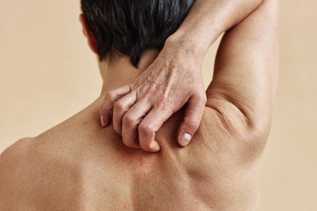 Closeup of mature woman scratching bare back a