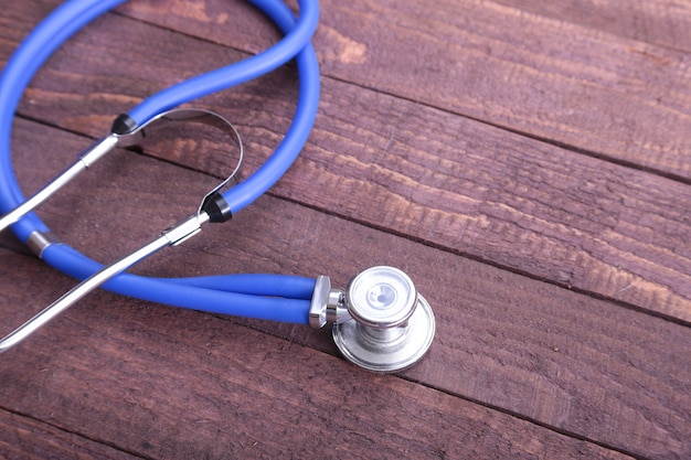 Closeup of a medical stethoscope, isolated on wooden background.