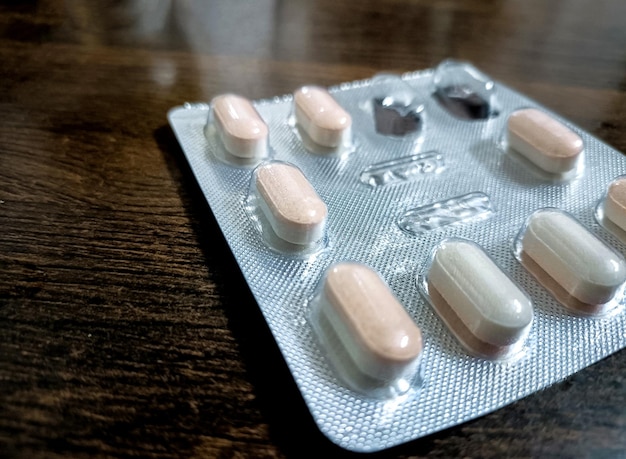 A closeup of medical tablets on wooden table