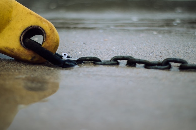 Closeup of the metallic chain in the sandy beach