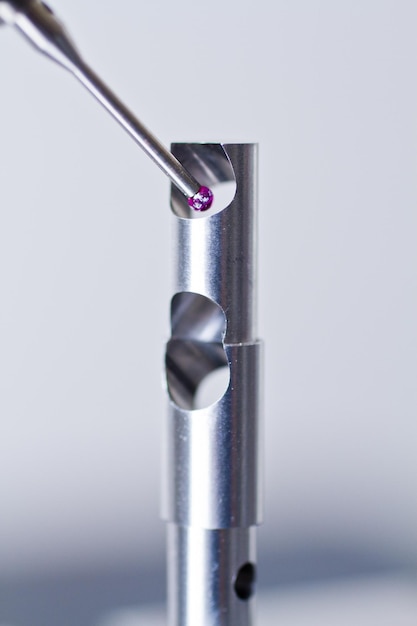 Photo closeup of metrology cmm probe inspecting metal part for minute flaws