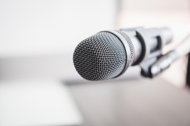 Closeup of microphone in lecture room background speech in seminar convention hall room Mic speaker of teacher on podium in college or university Workshop event and Entertainment broadcast concept