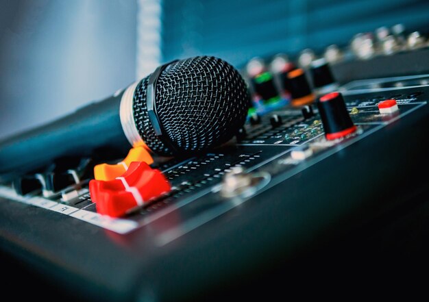 Photo closeup microphone on sound mixer in live broadcasting studio producer for sound record control