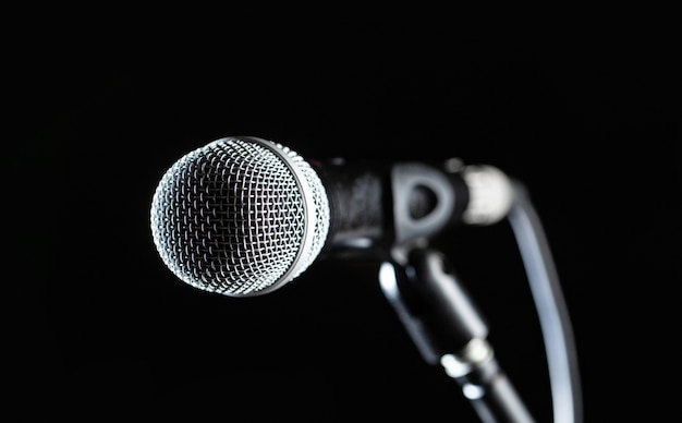 Closeup microphone. Vocal audio mic on a bleck background. Live music, audio equipment. Karaoke concert, sing sound. 