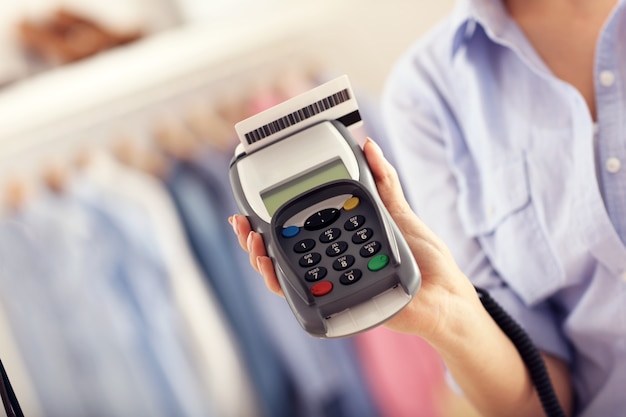 Closeup mid section of female customer paying in shop with credit card