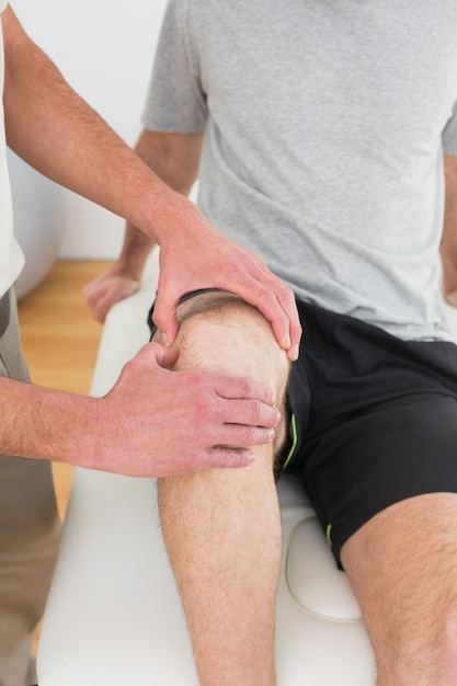 Closeup mid section of a man getting his knee examined
