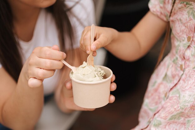 Closeup of mom and daughter eating ice cream delicious sweets