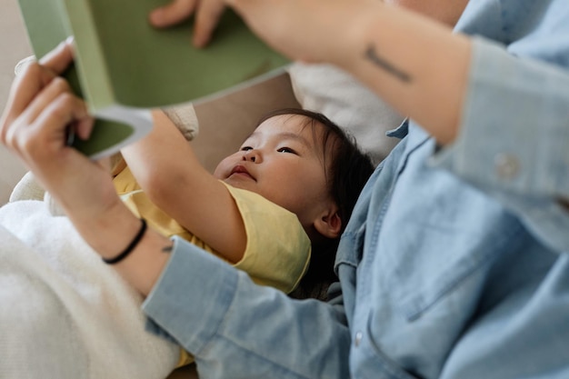 Closeup of mom reading book to her child before sleep at home