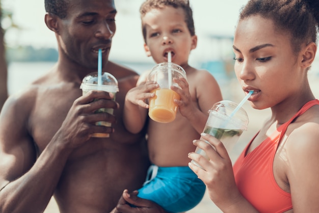 Closeup of Mother, Father and Son is Drinking Cold Cocktails