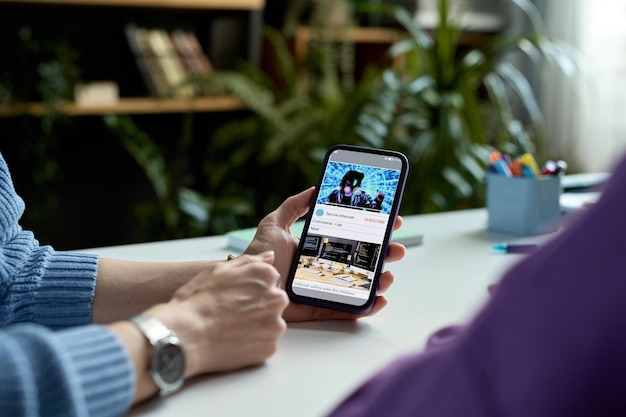 closeup of mother showing video on smartphone to her child while they sitting at desk