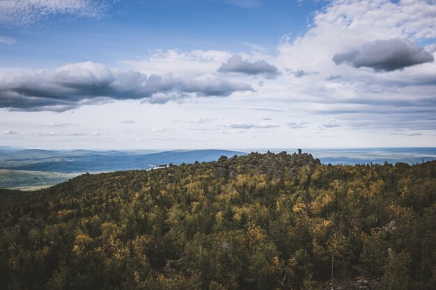 Scene di montagne del primo piano nel parco nazionale kachkanar, russia, europa. tempo nuvoloso, cielo di colore blu drammatico, alberi verdi lontani
