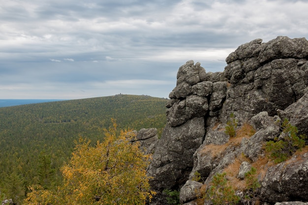 Closeup mountains scenes in national park Kachkanar, Russia, Europe. Cloudy weather, dramatic blue color sky, far away green trees