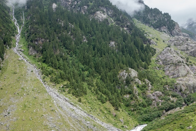 Closeup mountains scenes, walk to Trift Bridge in national park Switzerland, Europe. Summer landscape, sunshine weather, dramatic cloudy sky and sunny day