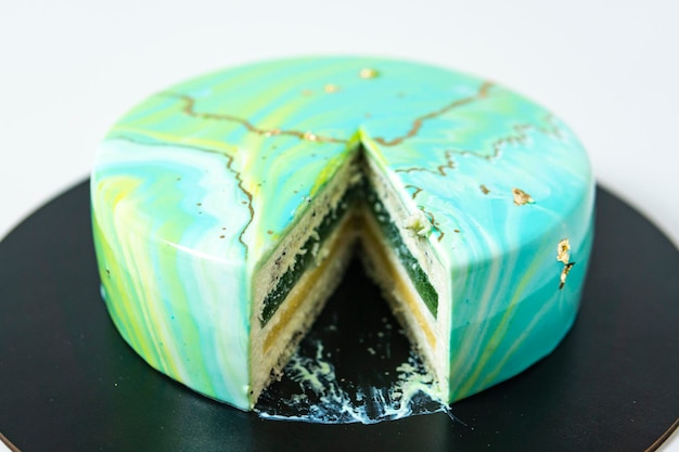 Close-up of cutting with knife mousse cake covered blue and green mirror  glaze. French dessert. Frozen mirror icing on the cake. 7297303 Stock Photo  at Vecteezy