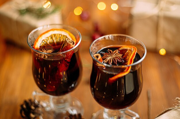 Closeup on mugs of glintwine with garland lights on the wooden table