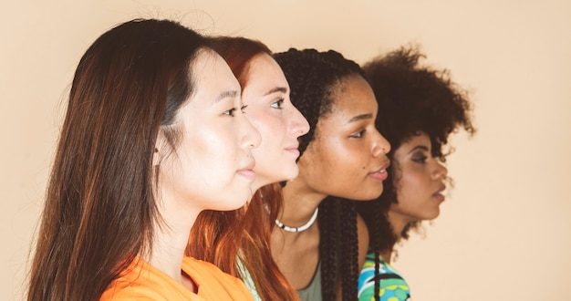 Closeup of multiethnic women on beige background, focus on asian woman