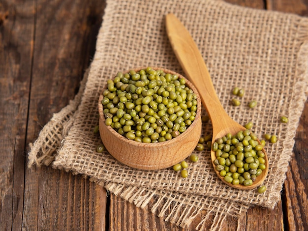 Photo closeup mung beans green mung beans in a wooden bowl on an old table