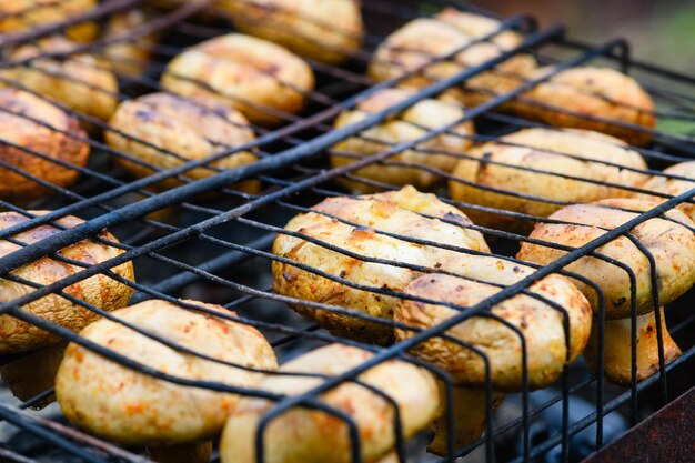 Foto close-up di funghi grigliati su una griglia da barbecue