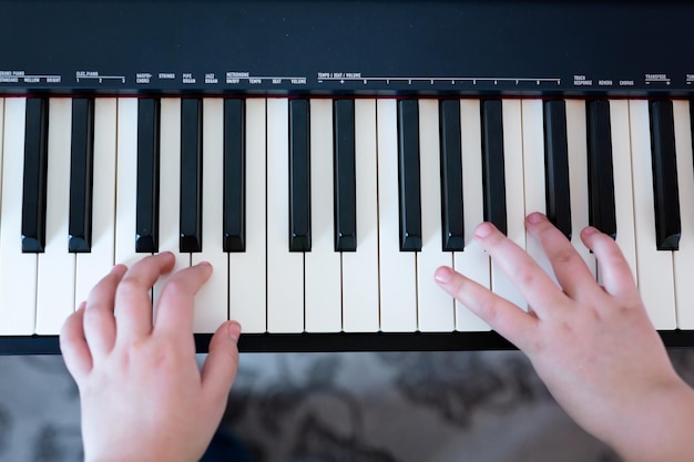 Closeup musician child hands playing piano on piano keyboard the concept of learning to play the piano classical music abstract music background