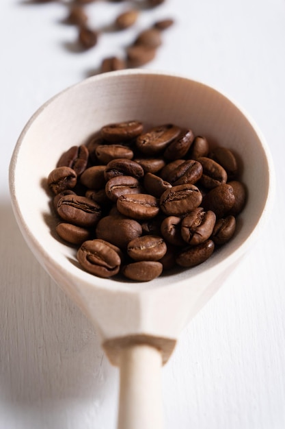 木のスプーンで自然に焙煎したコーヒー豆のクローズアップ