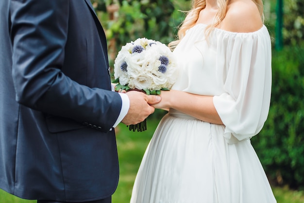 Closeup newly weds are holding each other's hand