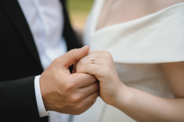 Closeup of newlyweds hands with engagement ring