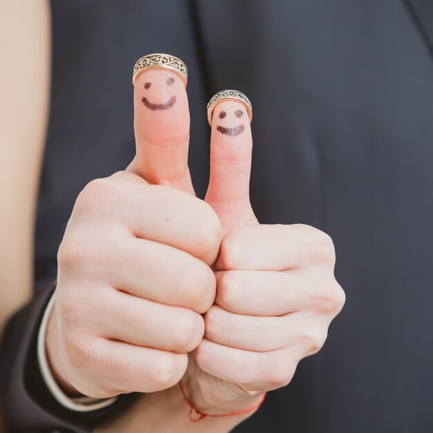 Closeup of newlyweds painted at fingers