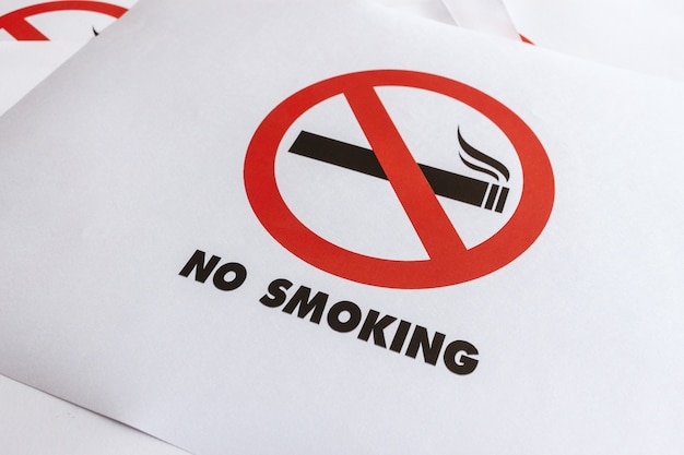 Крупным планом знак не курить на белой бумаге