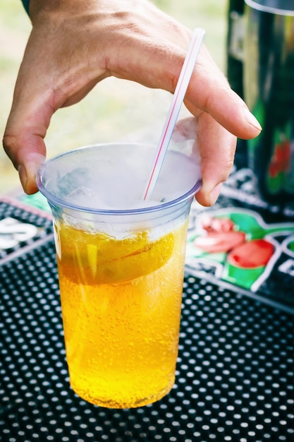 Closeup of nonalcoholic cocktail in plastic cups with dry ice and straw