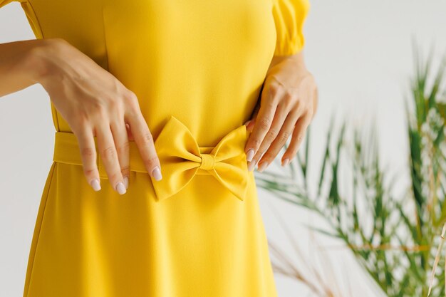 사진 칼라가 달린 노란색 드레스를 입은 패션 모델의 근접 촬영