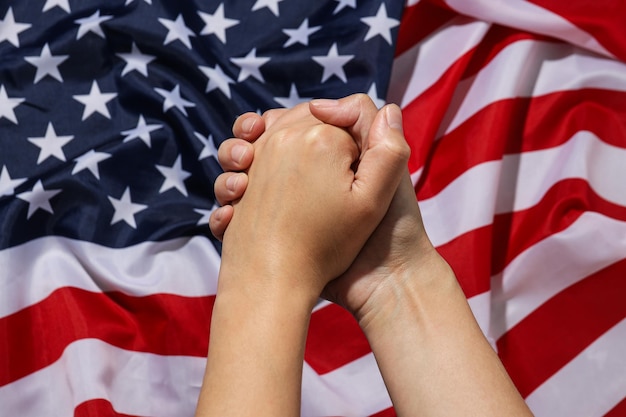 写真 アメリカの国旗を背景にした人間の握手のクローズアップ