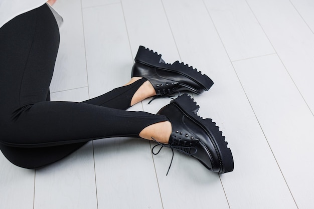 사진 검은 레깅스에 여성 다리에 검은 가죽 레이스 업 신발의 근접 촬영 여성의 세련된 가을 신발