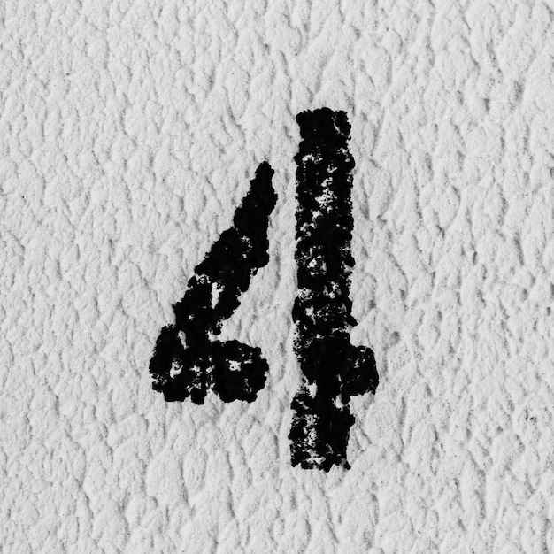 사진 회색 질감 벽에 검은색으로 칠해진 숫자 4의 근접 촬영