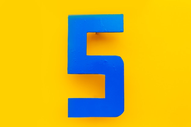 写真 黄色の背景に 5 の青い屋外番号のクローズ アップ。 sの手紙