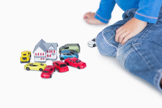 Фото Макрофотография мальчик, играя с игрушками и игрушечными автомобилями