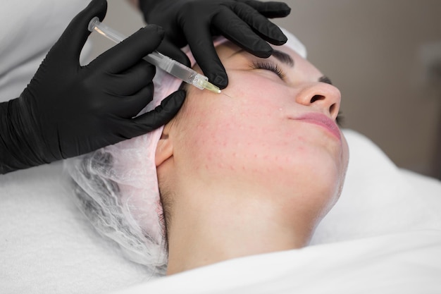写真 美容師のクローズアップは、引き締めのための若返りの顔の注射手順を行います