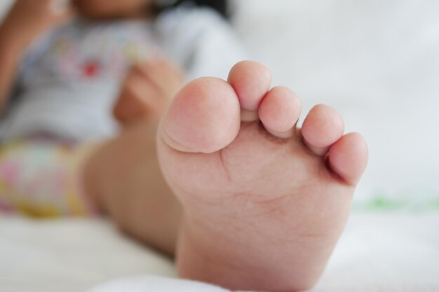 Фото Крупный план сухих детских ног на кровати