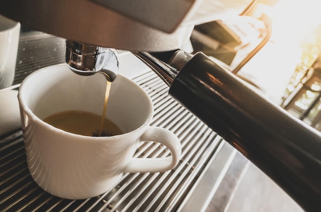 전문 커피 양조에 의해 커피 기계에서 붓는 에스프레소의 근접 촬영