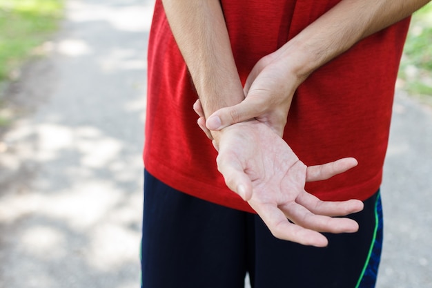 写真 運動のため彼女の痛みを伴う手首を保持している男性の腕のクローズアップ