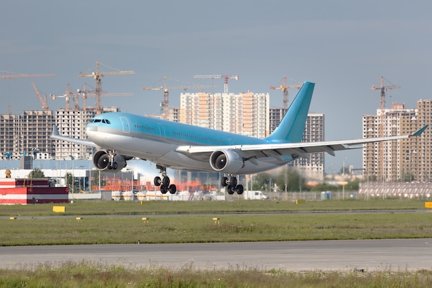 夏の空港の滑走路に着陸する準備ができている現代の旅客機のクローズアップ。