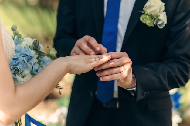 신랑의 클로즈업은 결혼식에서 신부의 손가락에 결혼 반지를 끼웁니다