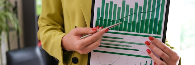 Фото Крупный план женщины-бухгалтера, показывающей финансовый отчет, указывающий на диаграмму документов статистических данных
